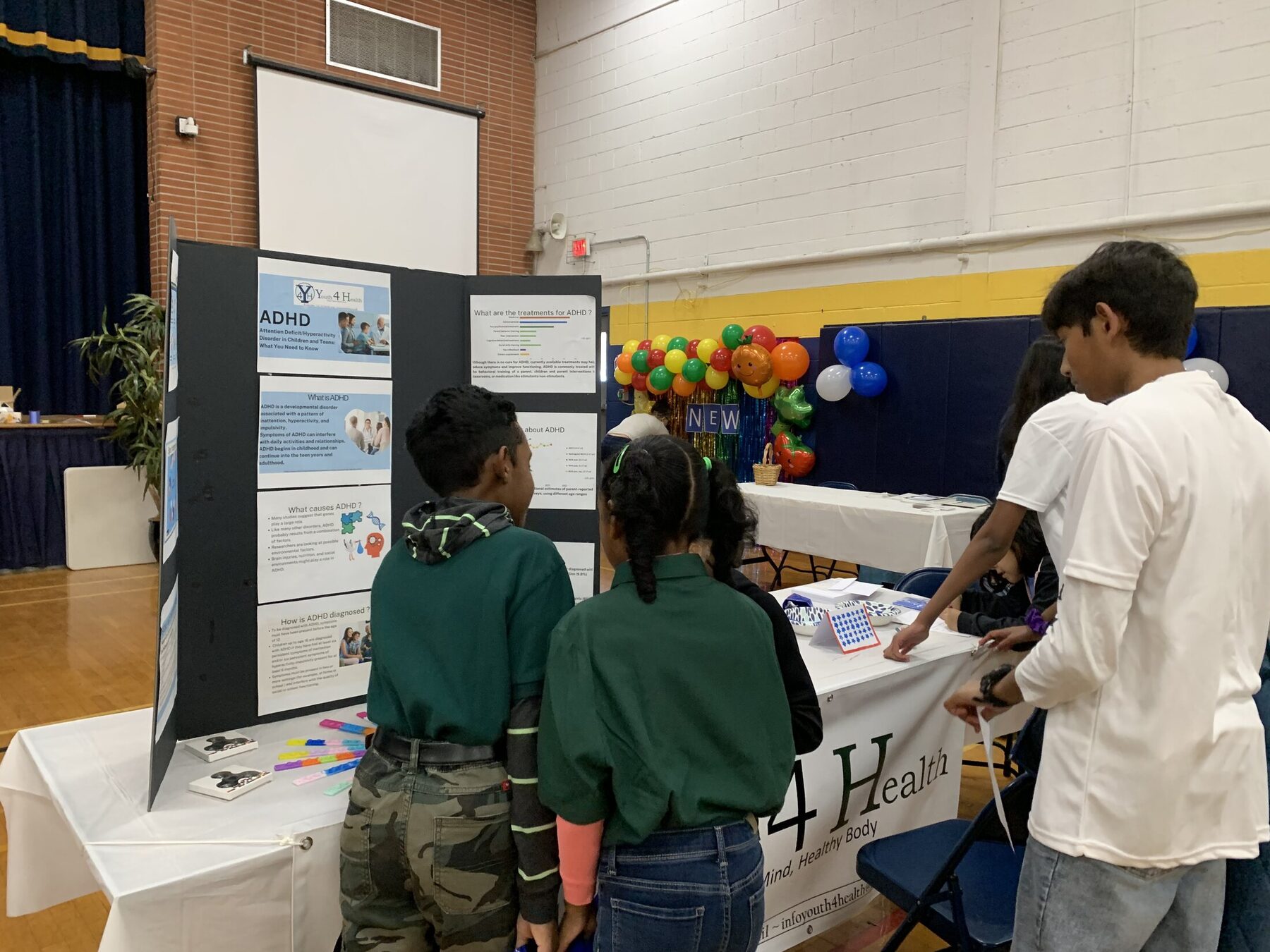 Youth volunteers welcoming children to the booth