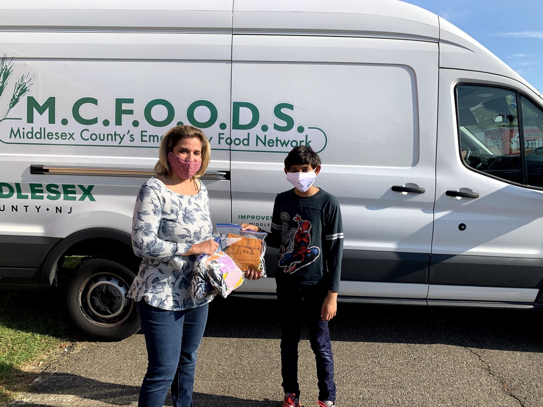 A youth volunteer presenting masks to the food network