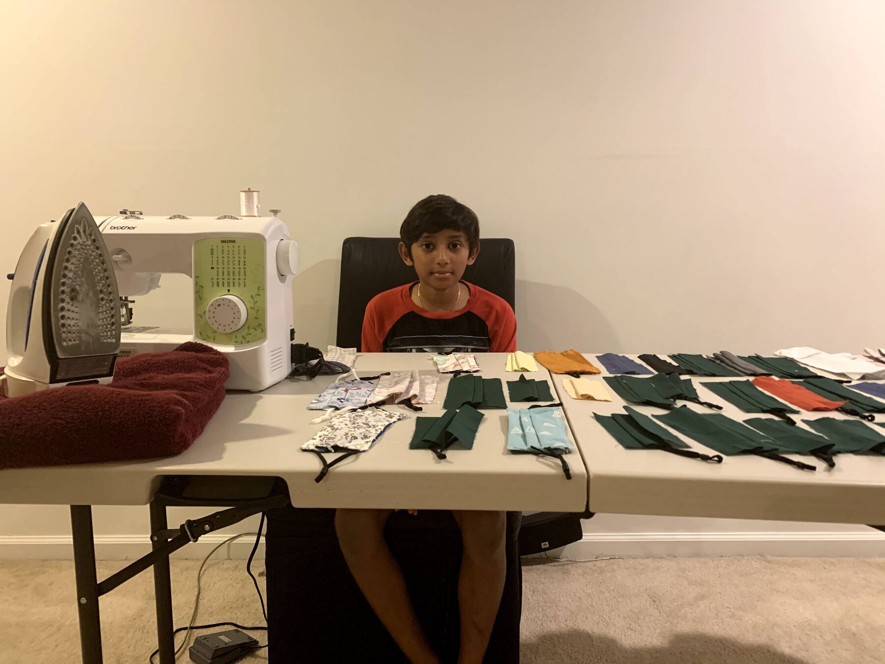 A youth volunteer sewing more reusable masks